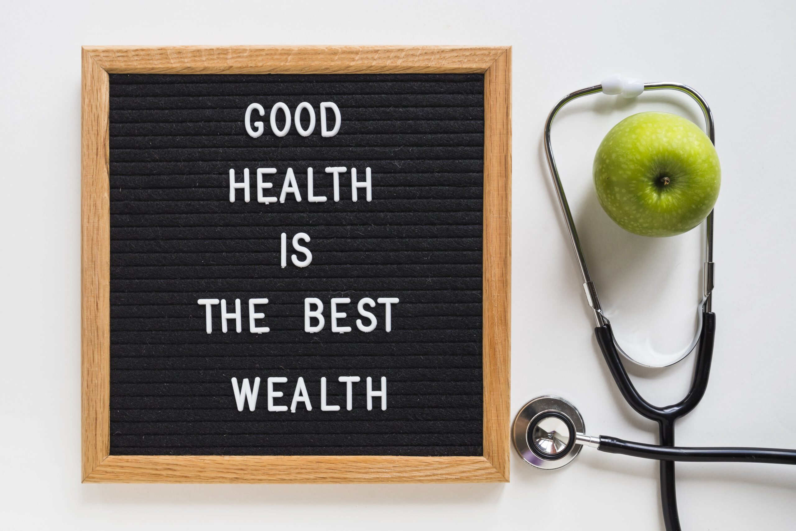 good health message board with green apple stethoscope white background min scaled