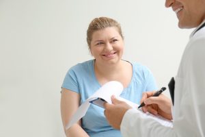 Overweight woman discussing test results with doctor in hospital